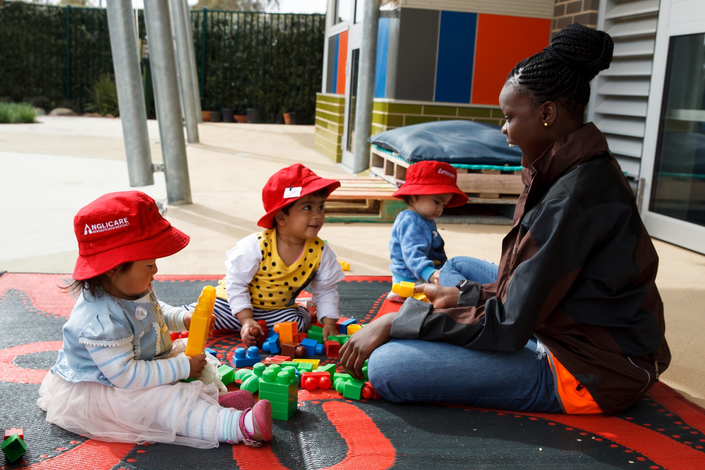 an educator playing with 3 toddlers